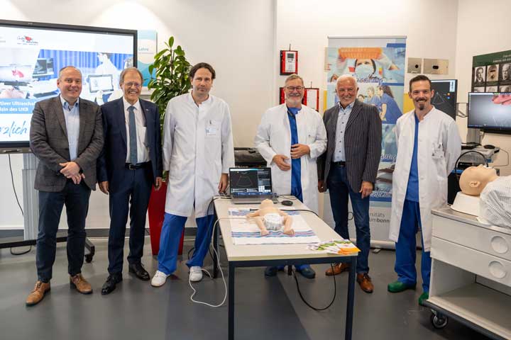 Prof. Bernd Weber, Dekan der Medizinischen Fakultät der Universität Bonn, Prof. Wolfgang Holzgreve, Ärztlicher Direktor und Vorstandsvorsitzender des UKB, Prof. Mark Coburn, Direktor der Klinik für Anästhesiologie und Operative Intensivmedizin des UKB, Prof. Ehrenfried Schindler, Sektionsleiter der Kinderanästhesiologie an der Klinik für Anästhesiologie und Operative Intensivmedizin des UKB, Günter Mies, 1. Vorsitzender des Vereins „Kleine Herzen Westerwald e. V.“ und Marc Rohner, Oberarzt an der Klinik für Anästhesiologie und Operative Intensivmedizin des UKB; bei der offiziellen Präsentation der Simulatoren 