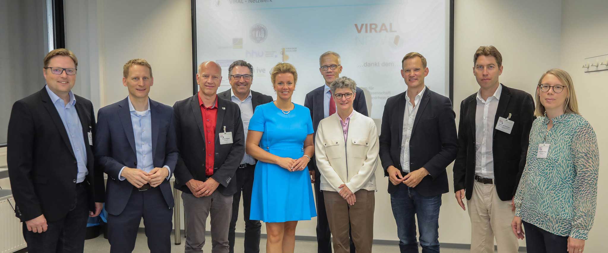 Prof. Dr. Jörg Timm (Virologie, Universität Düsseldorf), Prof. Dr. Florian Klein (Virologie, Universität Köln), Prof. Dr. Ulf Dittmer (Virologie, Universität Duisburg-Essen), Prof. Dr. Stephan Ludwig (Virologie, Universität Münster), Ina Brandes (Landesministerin, Ministerium für Kultur und Wissenschaft NRW), Prof. Dr. Nikolaj Klöcker (Dekan, Medizinische Fakultät Düsseldorf), Prof. Dr. Kirsten Schmieder (Ärztliche Direktorin, UK Düsseldorf), Prof. Dr. Hendrik Streeck (Virologie, UKB), Prof. Dr. Eike Steinmann (Virologie, Ruhr-Uni-Bochum), Dr. Anna-Kathrin Schupp (VIRAL Projektmanagerin, Universität Düsseldorf).