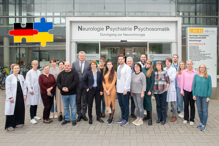 Prof. Alexandra Philipsen, Kommissarische Ärztliche Direktorin des UKB und Direktorin der Klinik für Psychiatrie und Psychotherapie am UKB, (Mitte links) begrüßte die Delegation der ukrainischen Fachärztinnen und –ärzte, darunter Mariana Yaremchuk, stellvertretende Leiterin der Caritas Sokal (3. v. l.), Dr. Roman Shved, leitender Direktor des regionalen Krankenhauses in Sokal (10. v. l.) und Dr. Olexander Huber, stellvertretender medizinischer Direktor der regionalen psychiatrischen Landesklinik in Lviv (6. v. l.), sowie Sergii Kasian, Bürgermeister der Stadt Sokal, Region Lviv (links neben Prof. Philipsen), zusammen mit Vitaliy Krusch, Initiator der Kooperation (11. v. l.), und Nelly Grunwald, Geschäftsführerin des VFG (6. v. r.).