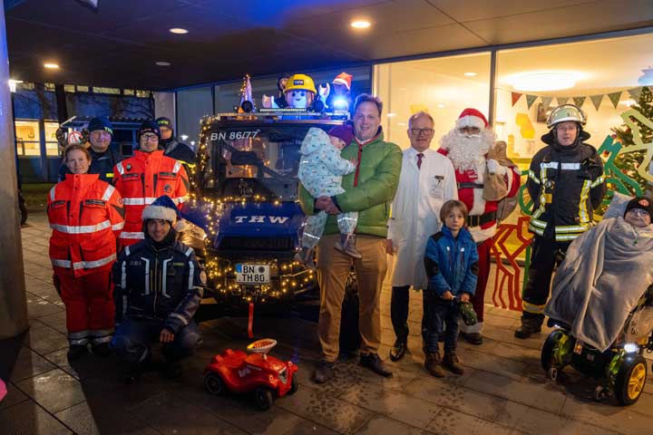 Prof. Rainer Ganschow (4. v. r.) begrüßte die über 70 Einsatzkräfte und den Weihnachtsmann zusammen mit kleinen Patientinnen und Patienten sowie Mitarbeitenden und ihren Familien zum diesjährigen ELKI Lichterfest.