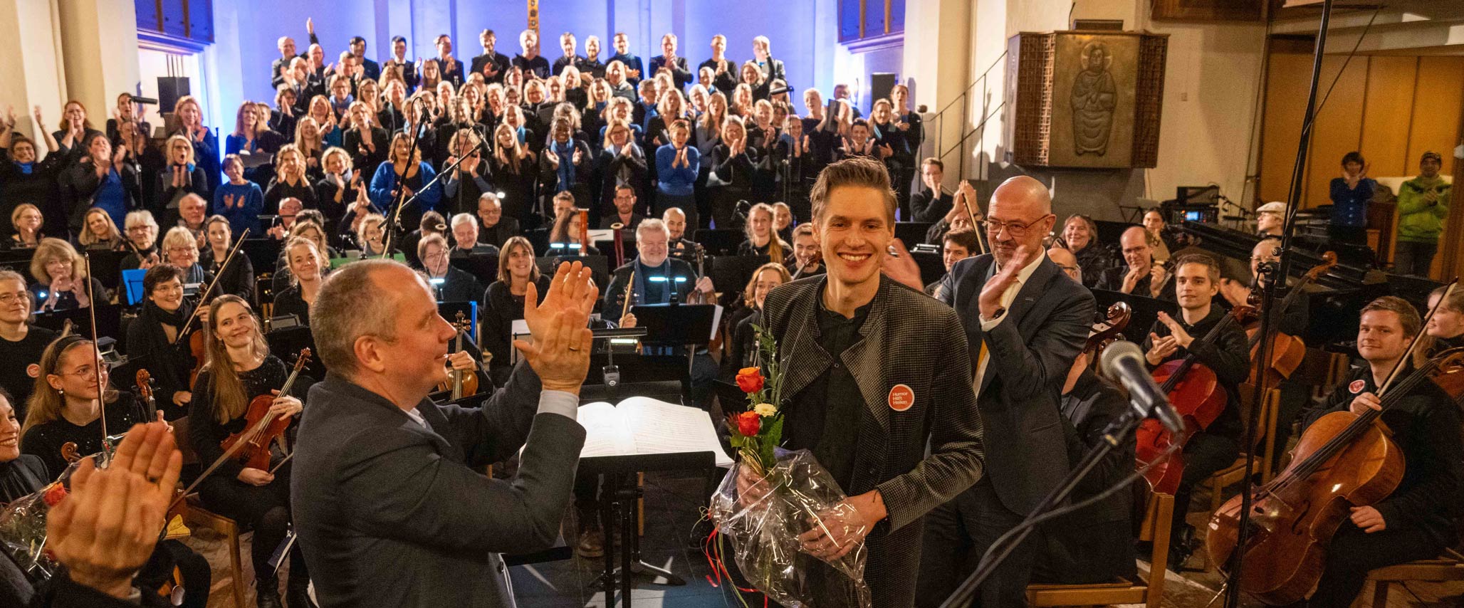 Prof. Bernd Weber (links) und Clemens Platzköster (rechts) gratulieren Chorleiter Dr. Rüber zu dem großartigen Erfolg.